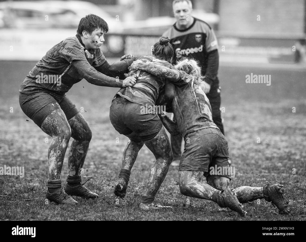 Partita inglese di rugby a 15 femminile amatoriale che gioca in condizioni umide e fangose. Foto Stock