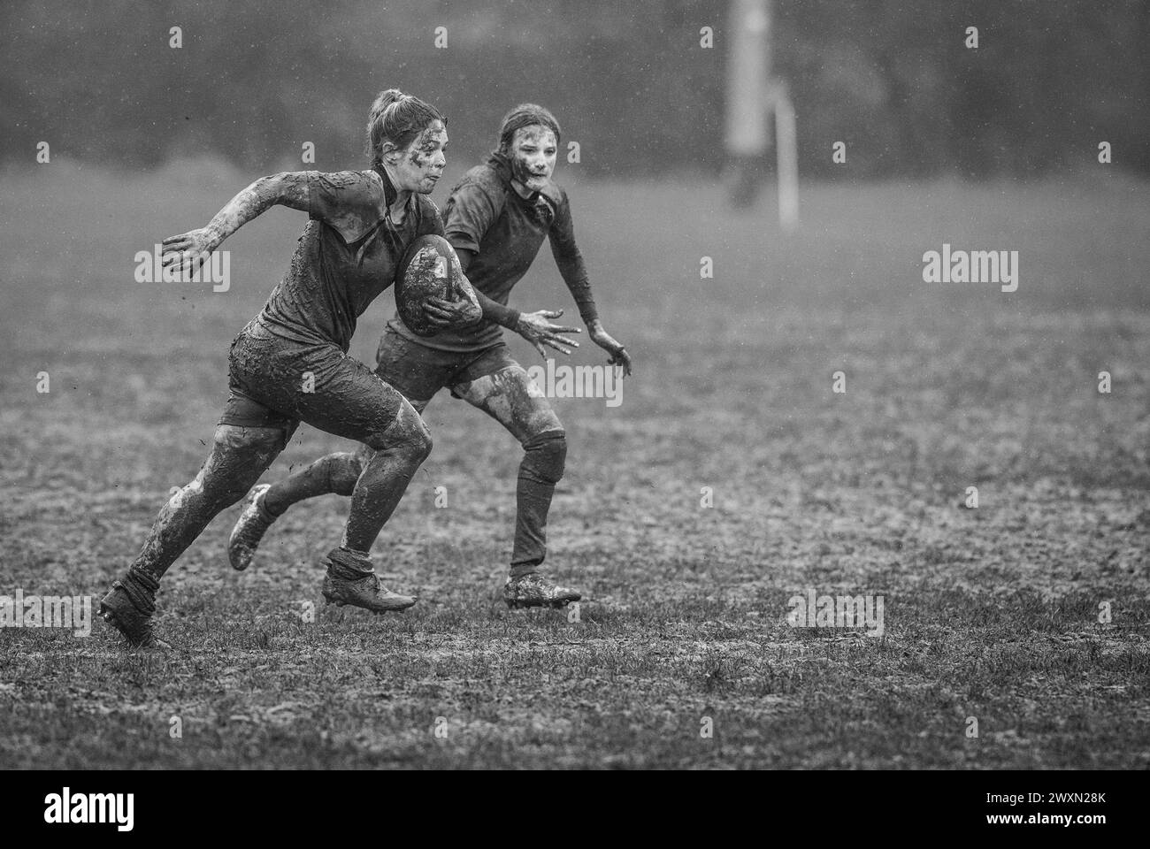 Partita inglese di rugby a 15 femminile amatoriale che gioca in condizioni umide e fangose. Foto Stock