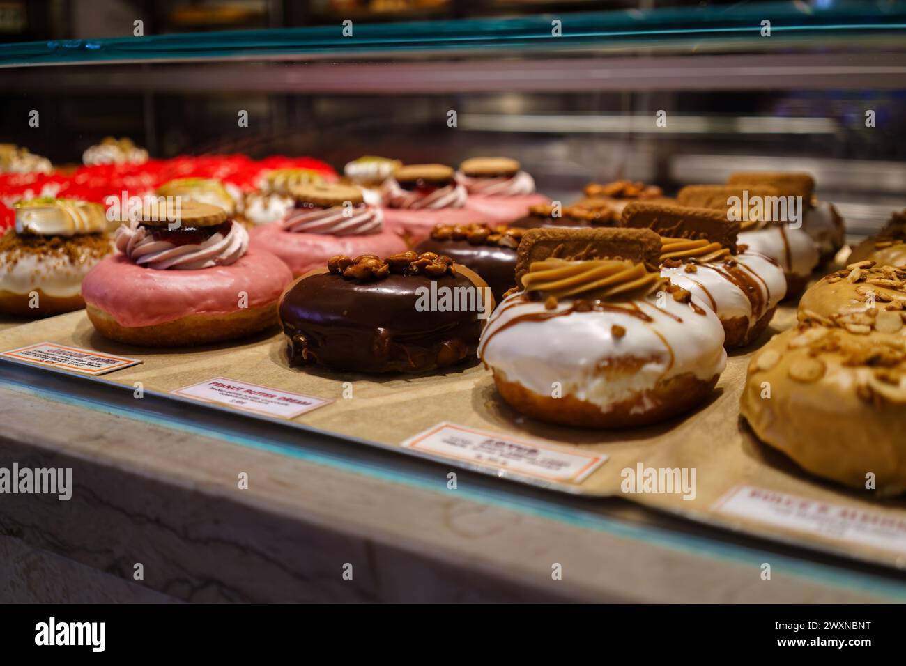 Doughnut Gourmet assortite in mostra presso una vetrina di prodotti da forno nel mercato Time Out. Lisbona, Portogallo. 2 febbraio 2024. Foto Stock