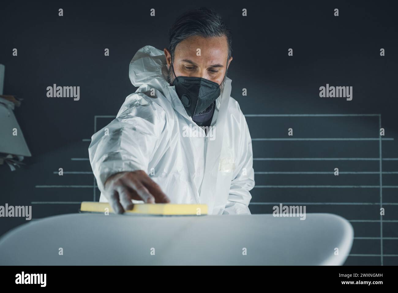 Produzione di tavole da surf, Shaper che lavora sui dettagli della tavola. Concetto di produzione industriale, professionale qualificata, professione e occupazione. Foto Stock