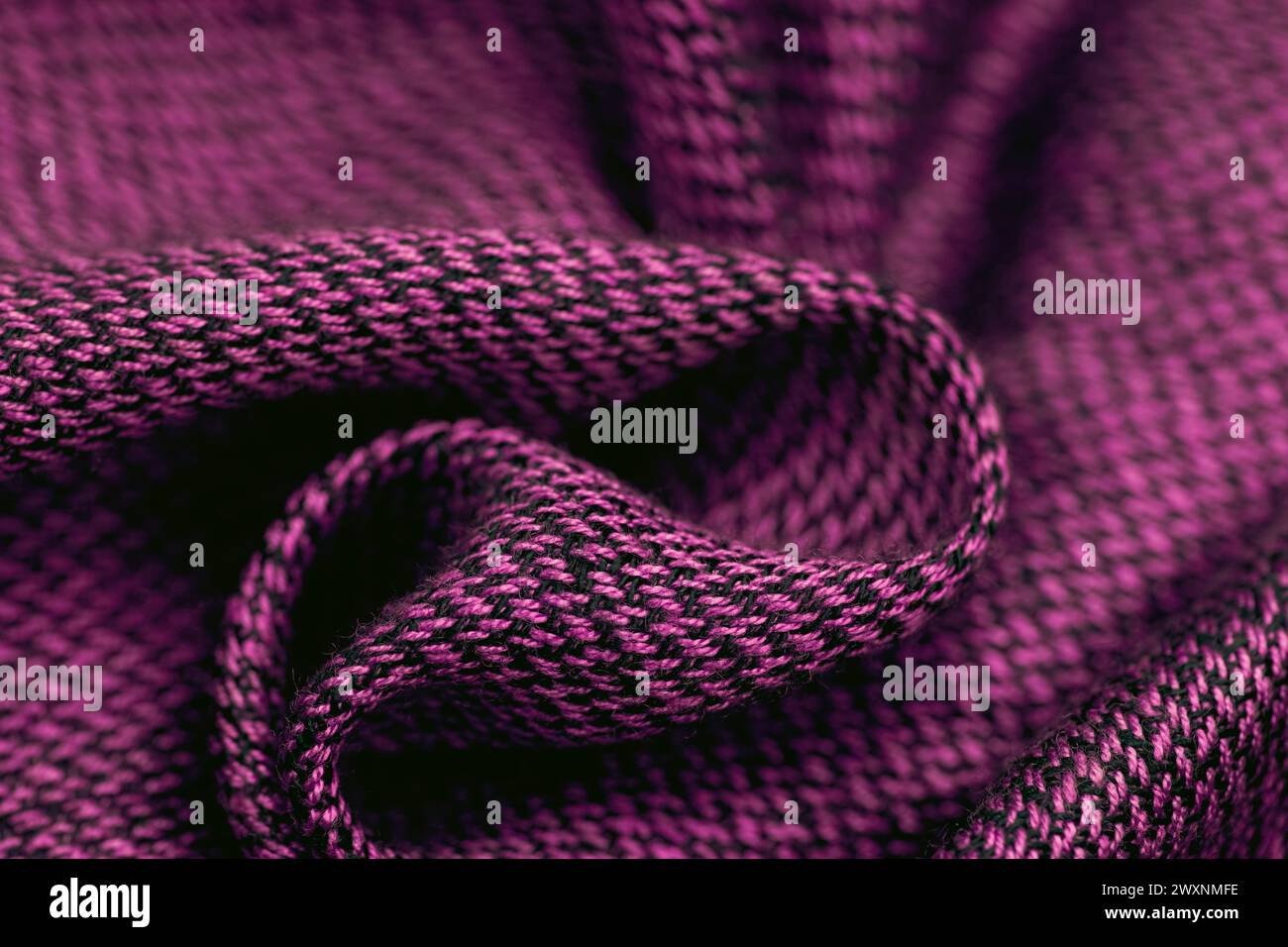 Un motivo intrecciato colorato su un tessuto a maglia viola Foto Stock