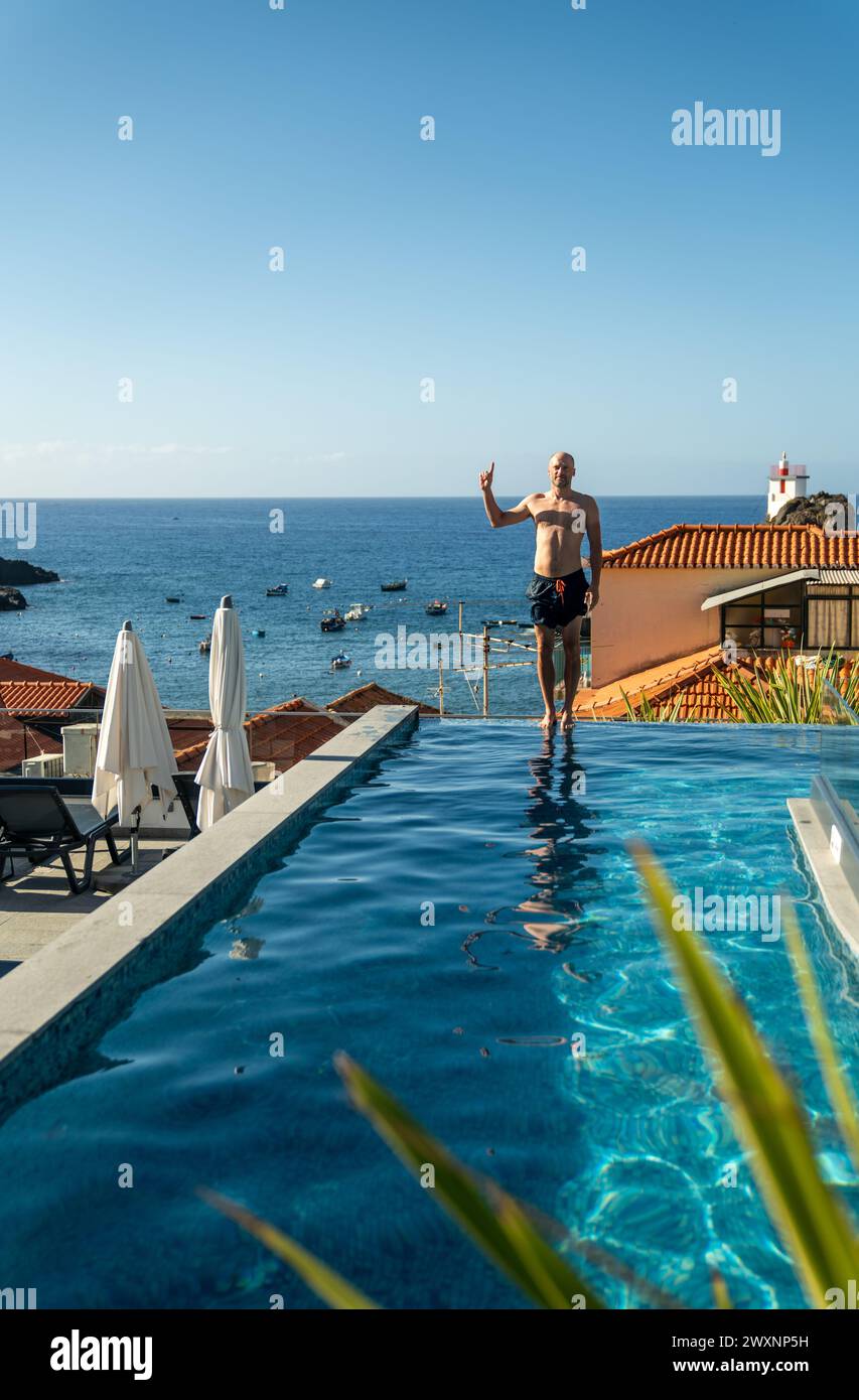 Un uomo in piedi di fronte a casa in acqua: L'isola di Madeira Foto Stock