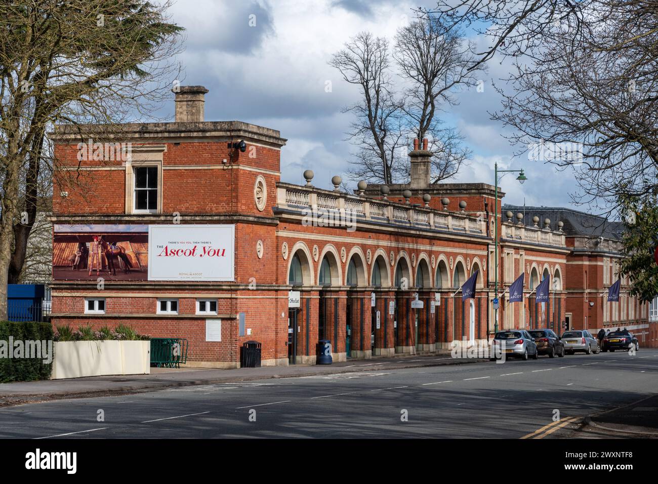 Vista lungo Ascot High Street con l'esterno dell'ippodromo, Berkshire, Inghilterra, Regno Unito. Uffici storici di grado II all'ippodromo di Ascot Foto Stock