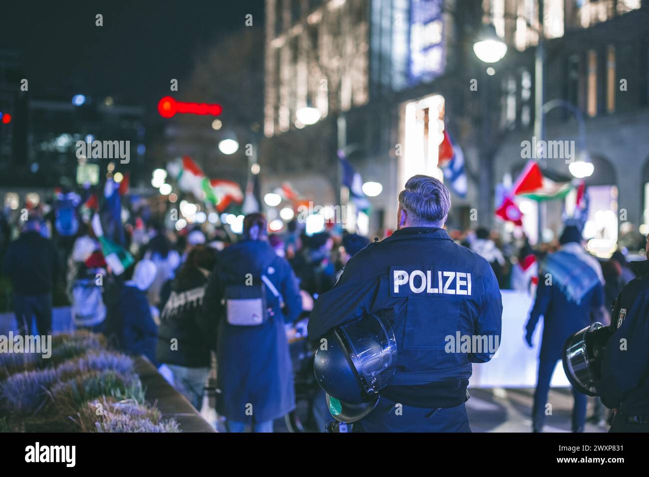 La polizia osserva le proteste a Berlino. Bandiere della palestina che sventolano tra le persone che sostengono la palestina sull'invasione israeliana di gaza. Foto Stock