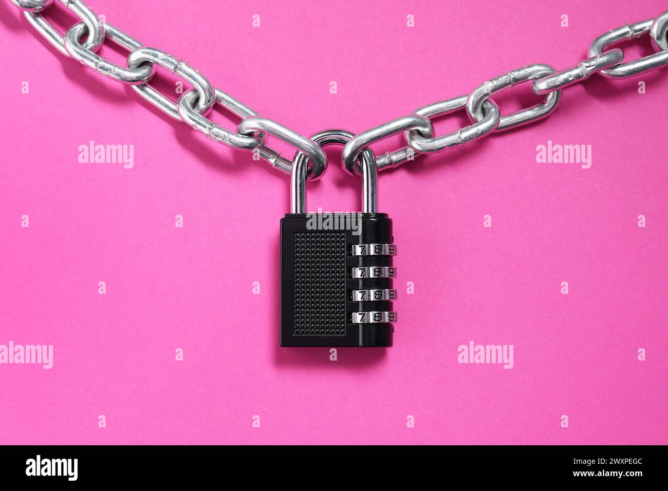 Lucchetto combinato in acciaio e catena su sfondo rosa, vista dall'alto Foto Stock