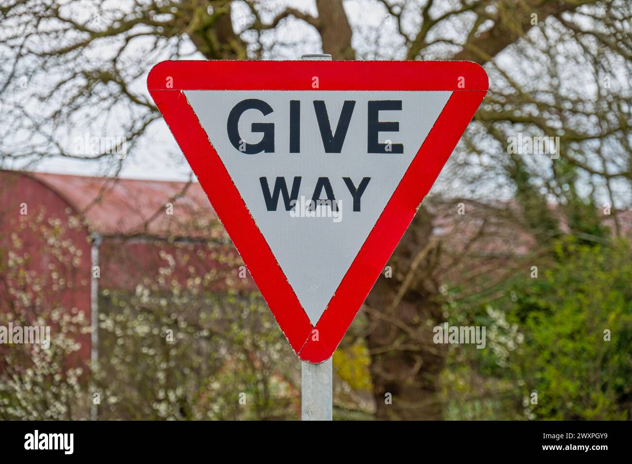 Il triangolo rosso dà un segnale di avvertimento su una strada suburbana del Regno Unito Foto Stock
