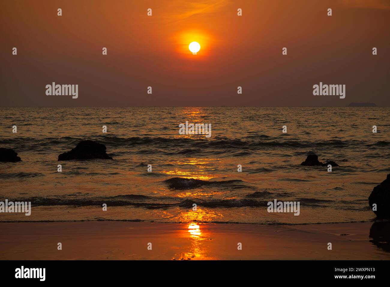 Splendido paesaggio di mare ondulato, spiaggia e cielo arancione durante il tramonto a Long Beach (Phra Ae Beach) a Koh Lanta, Thailandia. Foto Stock
