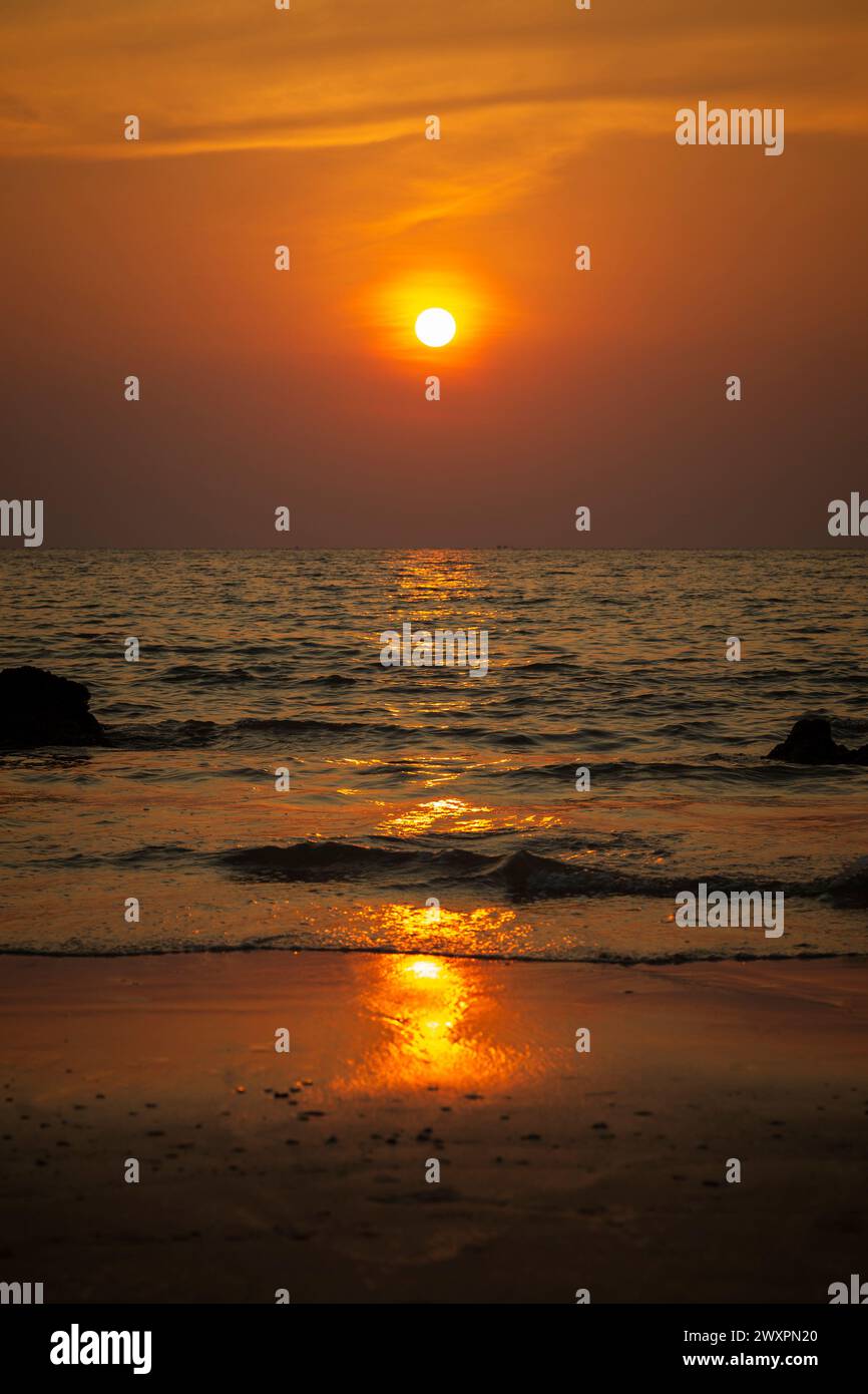 Splendido paesaggio di mare ondulato, spiaggia e cielo arancione durante il tramonto a Long Beach (Phra Ae Beach) a Koh Lanta, Thailandia. Foto Stock