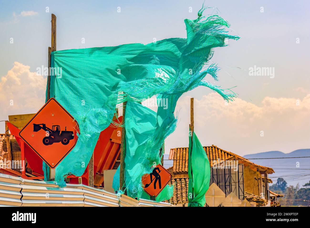 Un panno verde di ombra strappato agitato dal vento, in un cantiere nella città coloniale di Villa de Leyva, nella Colombia centrale. Foto Stock