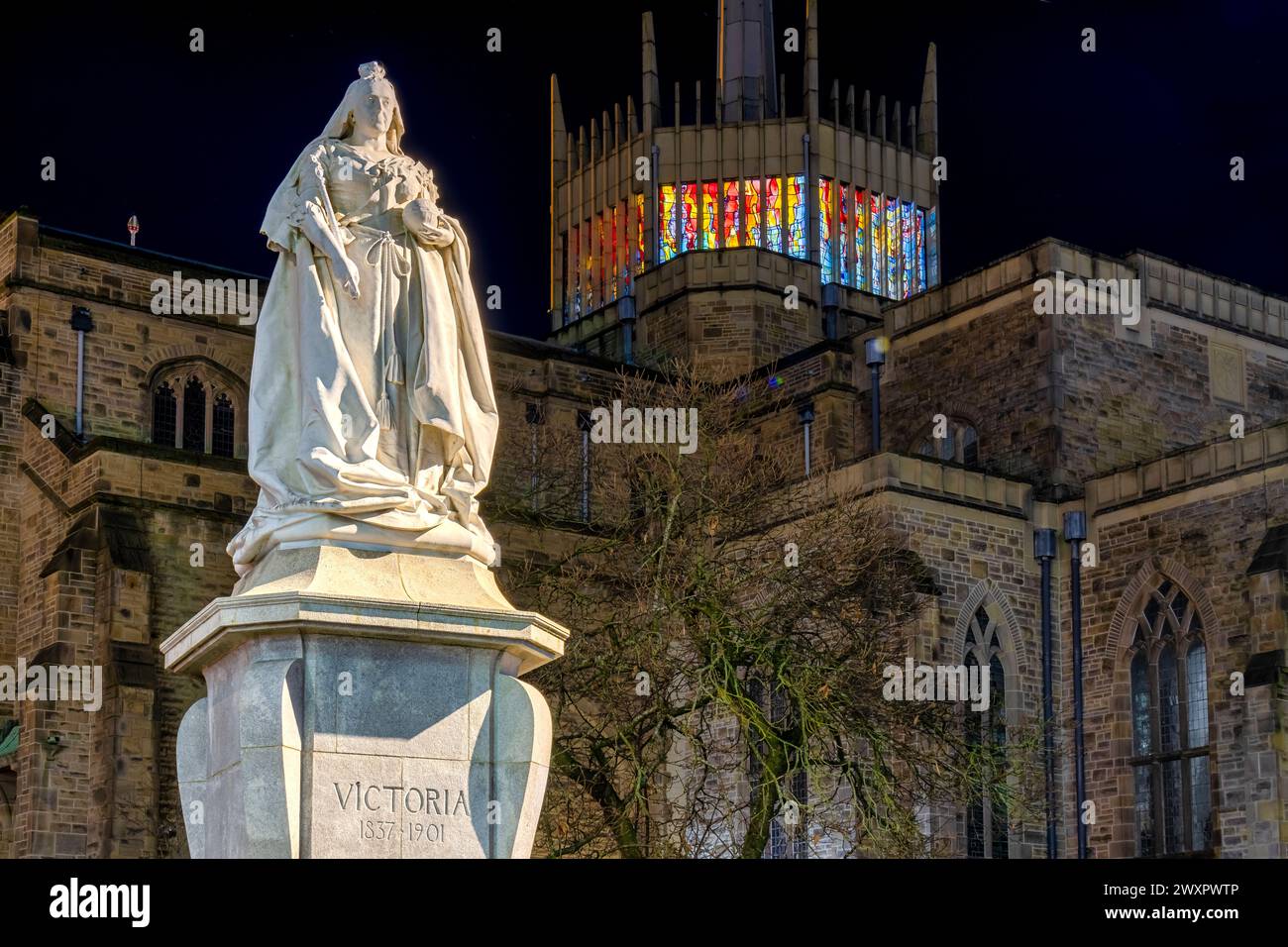 Cattedrale di Blackburn con statua della Regina Vittoria al tramonto. La statua è un monumento classificato di grado II situato a Blackburn, Lancashire, Regno Unito. Foto Stock