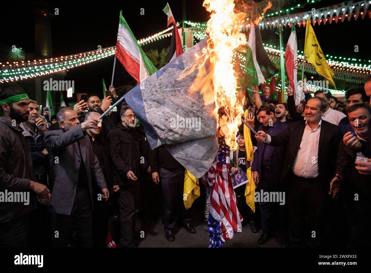 Teheran, Iran. 1 aprile 2024. I manifestanti iraniani bruciano rappresentazioni delle bandiere statunitensi e israeliane durante il loro raduno per condannare l'uccisione di membri delle guardie rivoluzionarie iraniane in Siria, presso la Palestina Sq. Nel centro di Teheran. Un attacco aereo israeliano che ha demolito il consolato iraniano in Siria ha ucciso due generali iraniani e cinque ufficiali, funzionari siriani e iraniani hanno detto lunedì. (Foto di Sobhan Farajvan/Pacific Press) credito: Pacific Press Media Production Corp./Alamy Live News Foto Stock