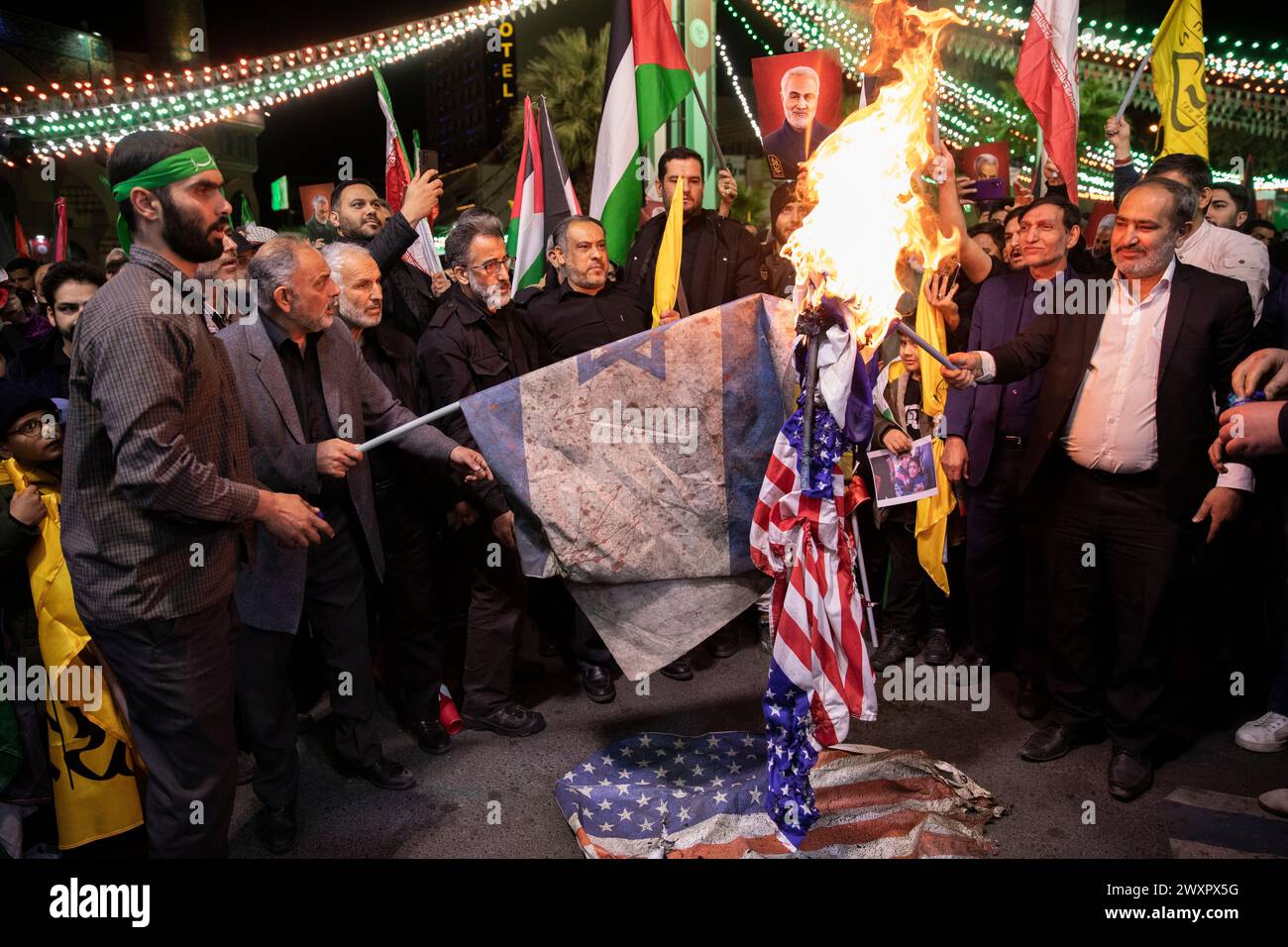 Teheran, Iran. 1 aprile 2024. I manifestanti iraniani bruciano rappresentazioni delle bandiere statunitensi e israeliane durante il loro raduno per condannare l'uccisione di membri delle guardie rivoluzionarie iraniane in Siria, presso la Palestina Sq. Nel centro di Teheran, Iran, lunedì 1 aprile 2024. Un attacco aereo israeliano che ha demolito il consolato iraniano in Siria ha ucciso due generali iraniani e cinque ufficiali, funzionari siriani e iraniani hanno detto lunedì. (Foto di Sobhan Farajvan/Pacific Press) credito: Pacific Press Media Production Corp./Alamy Live News Foto Stock