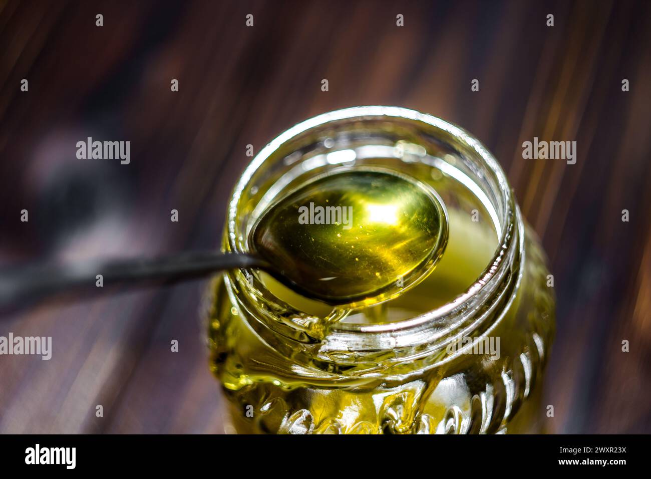 Il cucchiaio di miele sul vaso di vetro Foto Stock