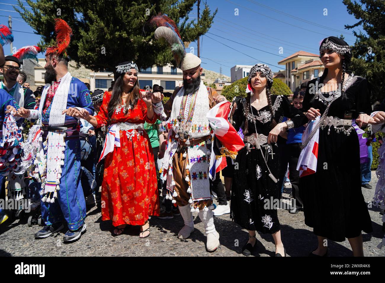 Dohuk, Iraq. 1 aprile 2024. Gli assiri vestiti con abiti tradizionali ballano sulle melodie di una band musicale durante le celebrazioni Aketo, il capodanno assiro 6774, a Dohuk. (Foto di Ismael Adnan/SOPA Images/Sipa USA) credito: SIPA USA/Alamy Live News Foto Stock