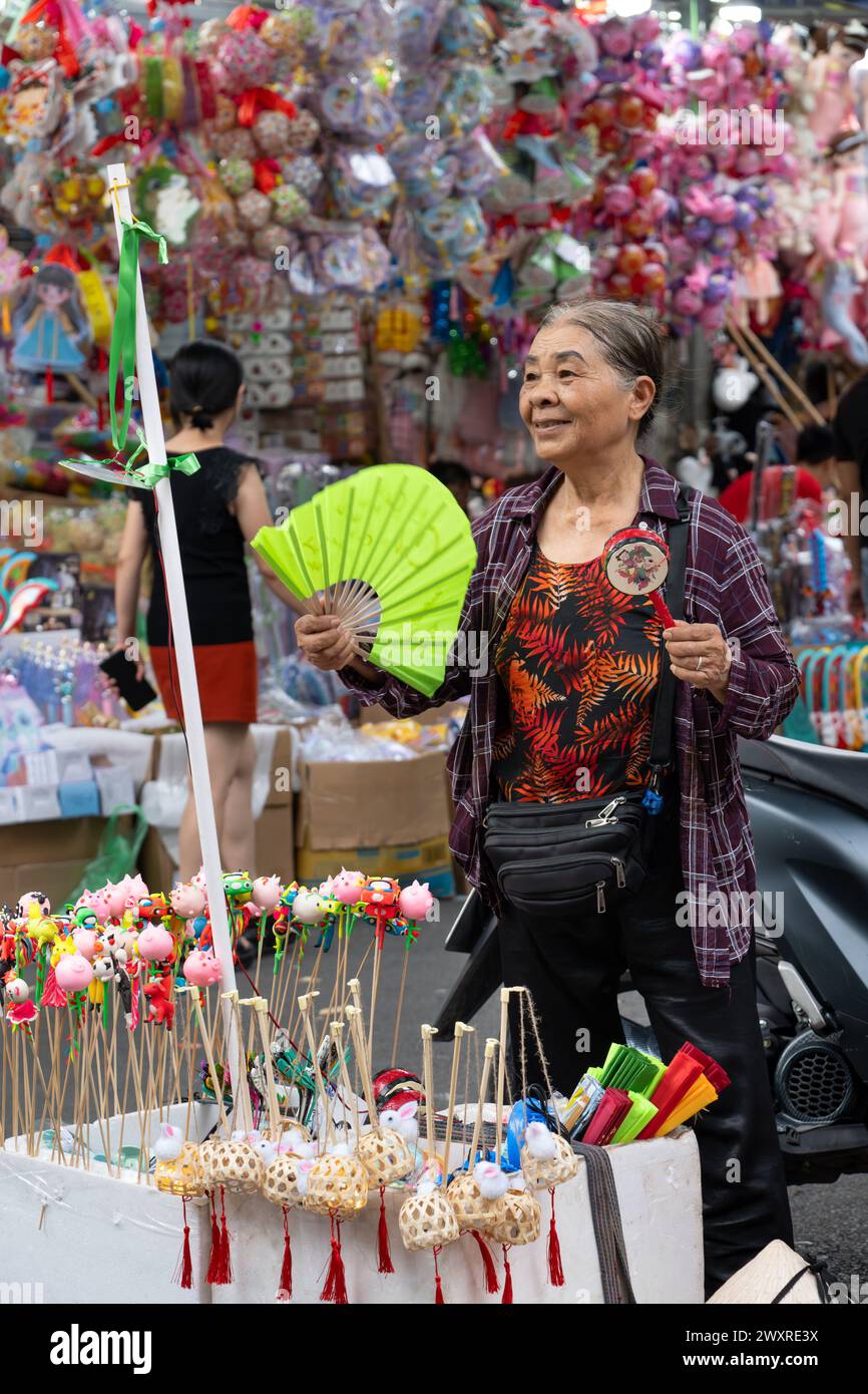 Donna che vende giocattoli a Toy Street di Hanoi, Vietnam Foto Stock