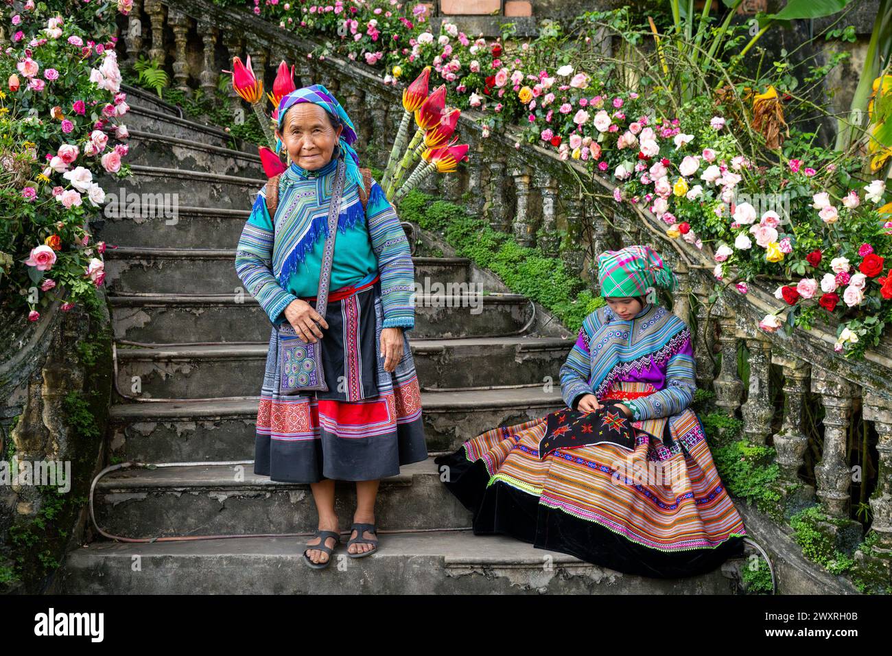 Donne Hmong di fiori sedute sulle scale del Palazzo dei Re Hmong (Vau Meo) a Bac ha, provincia di Lao Cai, Vietnam Foto Stock