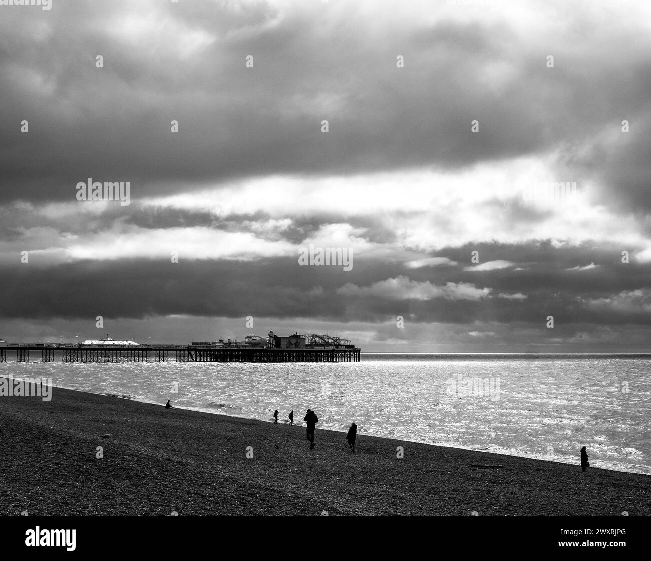 Brighton Regno Unito 1 aprile 2024 - il sole cerca di sbirciare attraverso nuvole scure sul Molo del Palazzo di Brighton nel giorno festivo del lunedì di Pasqua: Credito Simon Dack Foto Stock