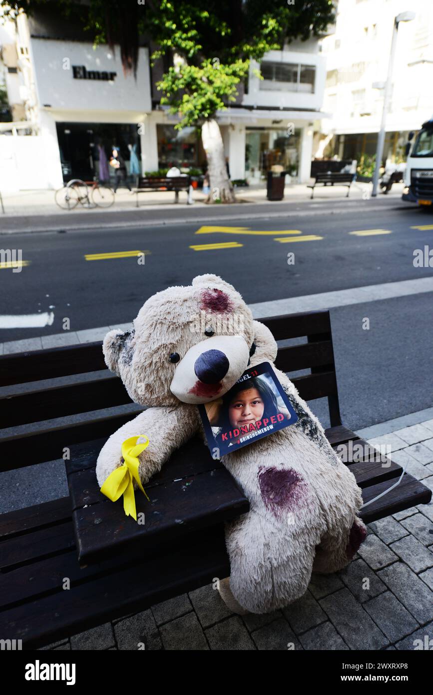 Grandi orsacchiotti, macchiati di sangue finto, sono collocati sulle panchine lungo via Dizengoff di Tel Aviv, come ricordo degli ostaggi detenuti a Gaza. Foto Stock