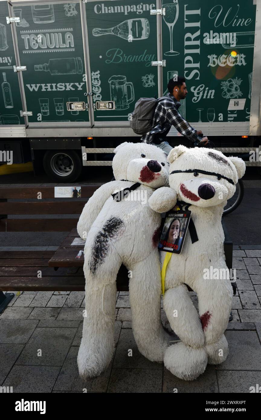 Grandi orsacchiotti, macchiati di sangue finto, sono collocati sulle panchine lungo via Dizengoff di Tel Aviv, come ricordo degli ostaggi detenuti a Gaza. Foto Stock
