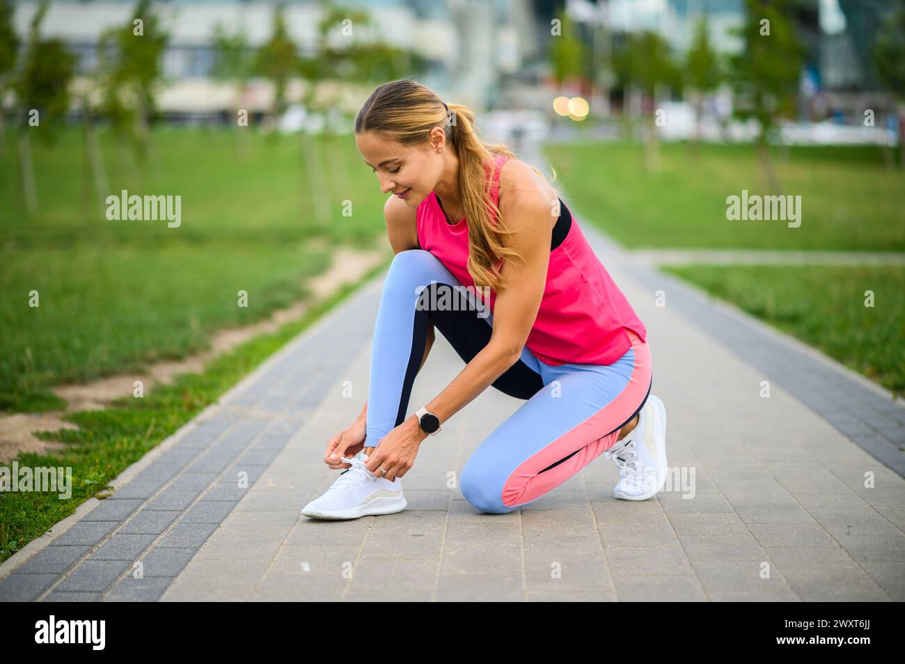 Una giovane atleta si prepara a fare jogging in un parco urbano Foto Stock