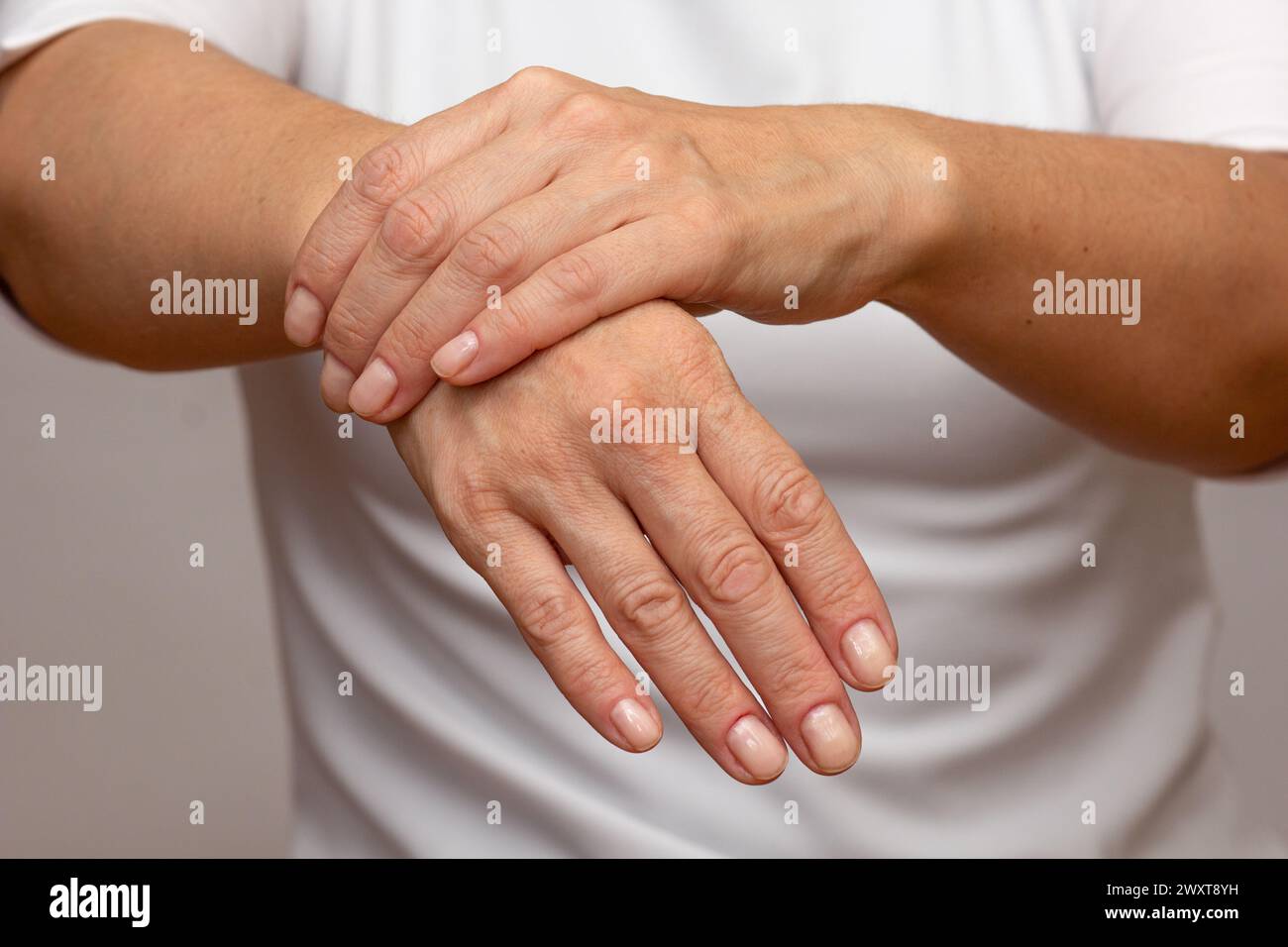 Mani di donna che mostrano dolore al polso destro Foto Stock