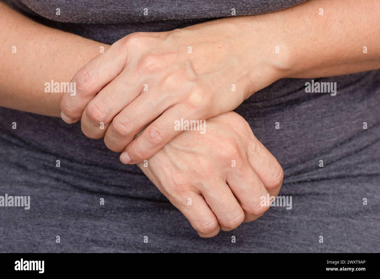 Mani di donna che mostrano dolore al polso destro Foto Stock