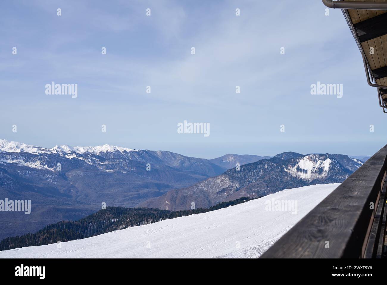 Ampia vista sulle piste innevate e sulle montagne da una terrazza del deposito sci. Foto Stock