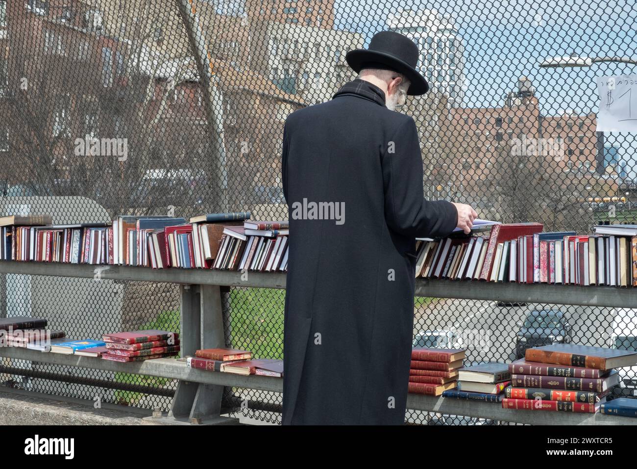 In un caldo giorno primaverile gli ebrei ortodossi fanno acquisti in un negozio pop-up che vende libri religiosi. Sul cavalcavia BQE a Brooklyn, New York. Foto Stock
