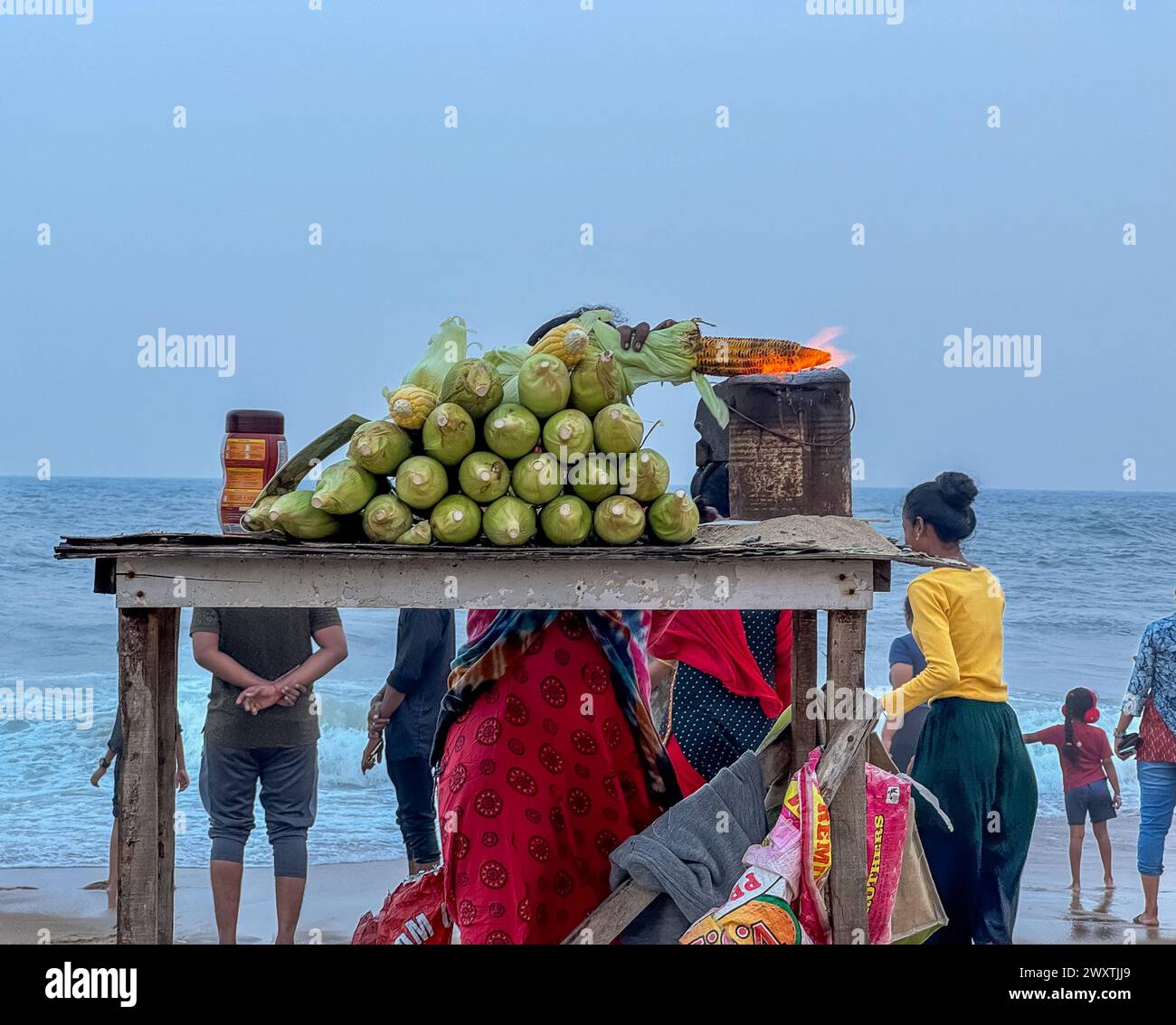 Chennai, Tamil Nadu, India - 23 dicembre 2023: Hawker vende mais dolce fresco ai visitatori della spiaggia, Elliot's Beach, Chennai, Tamil Nadu Foto Stock