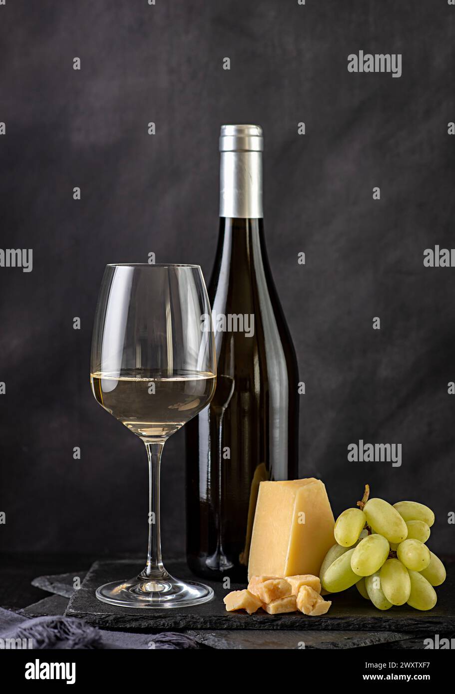 Fotografia gastronomica di vino bianco, formaggio; parmigiano, uva, fetta; wineglass, bottiglia, cantina, bevanda, sfondo, festeggiamenti, Foto Stock