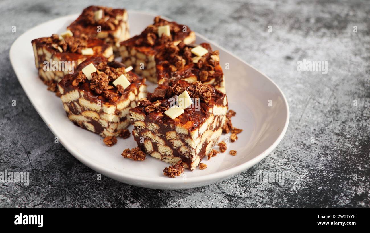 Torta pigra o torta a mosaico con muesli e cioccolato . Fatto in casa, non c'era una torta al cioccolato sul tavolo. Foto Stock