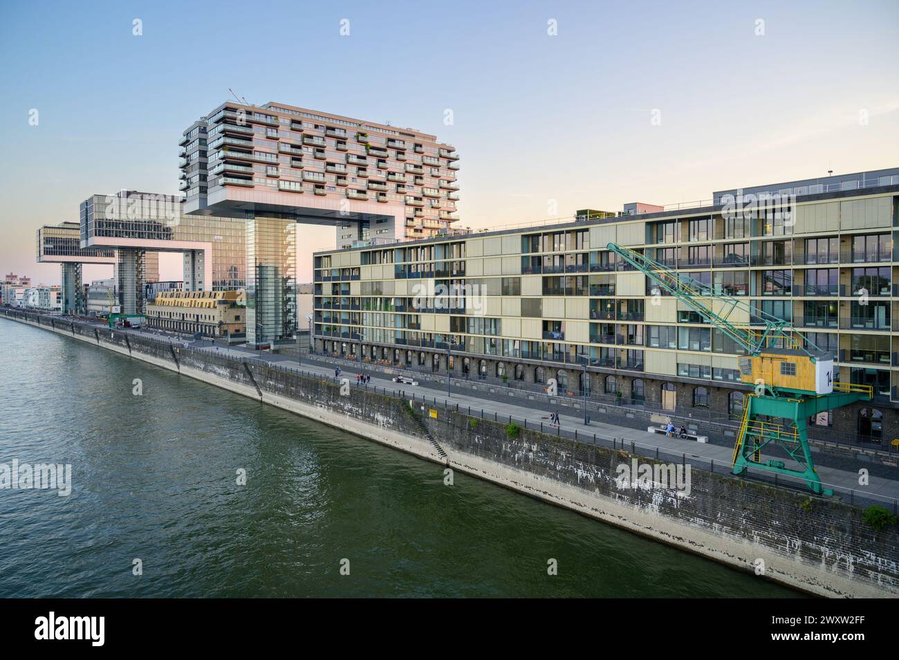 Promenade presso il porto del Reno di Colonia, Germania: Appartamenti moderni e edifici per uffici fiancheggiano il porto industriale formale Foto Stock