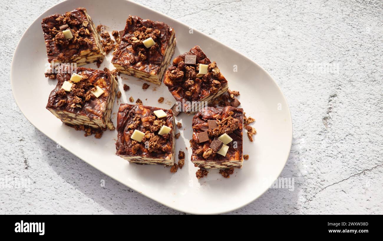 Torta pigra o torta a mosaico con muesli e cioccolato . Fatto in casa, non c'era una torta al cioccolato sul tavolo. Foto Stock