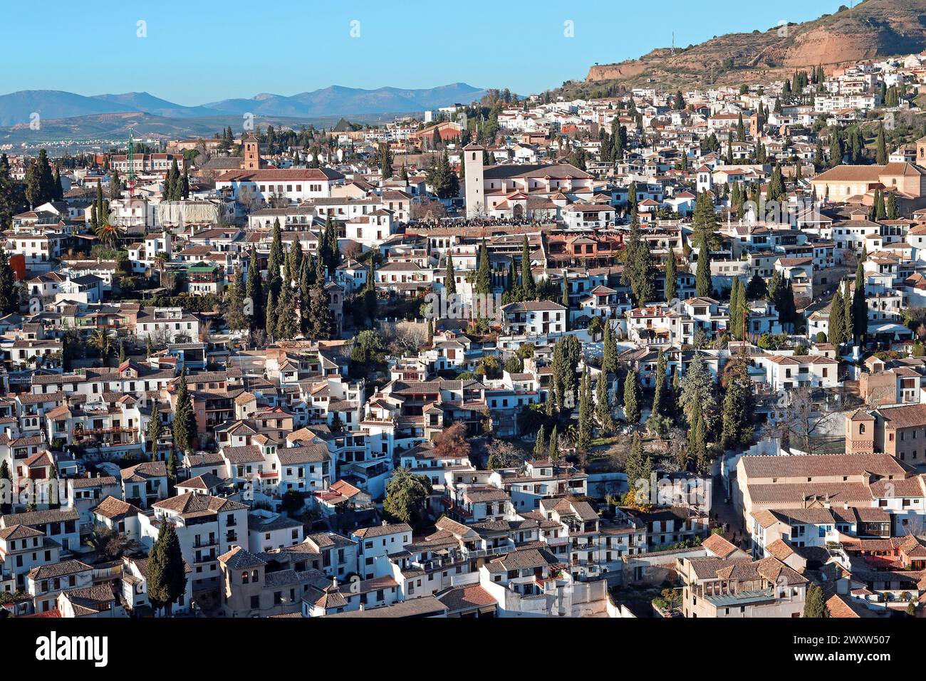 Colpo largo dalla collina Sabika dei quartieri Albaicín e Sacromonte, Granada, Andalusia, Spagna, con la torre della chiesa di San Nicolàs Foto Stock