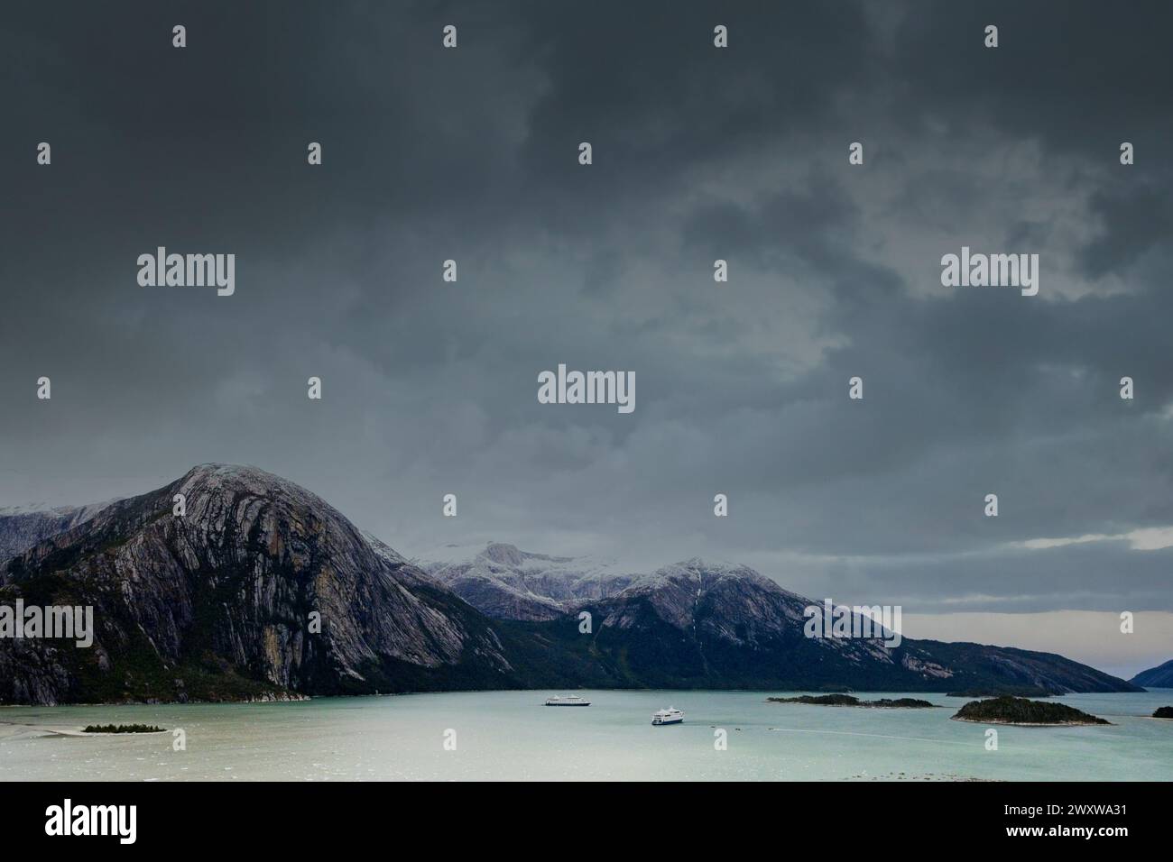 Due navi da crociera Australis attraversate dalla baia di Pia e dalle montagne circostanti che ospitano il ghiacciaio Pia. Foto Stock