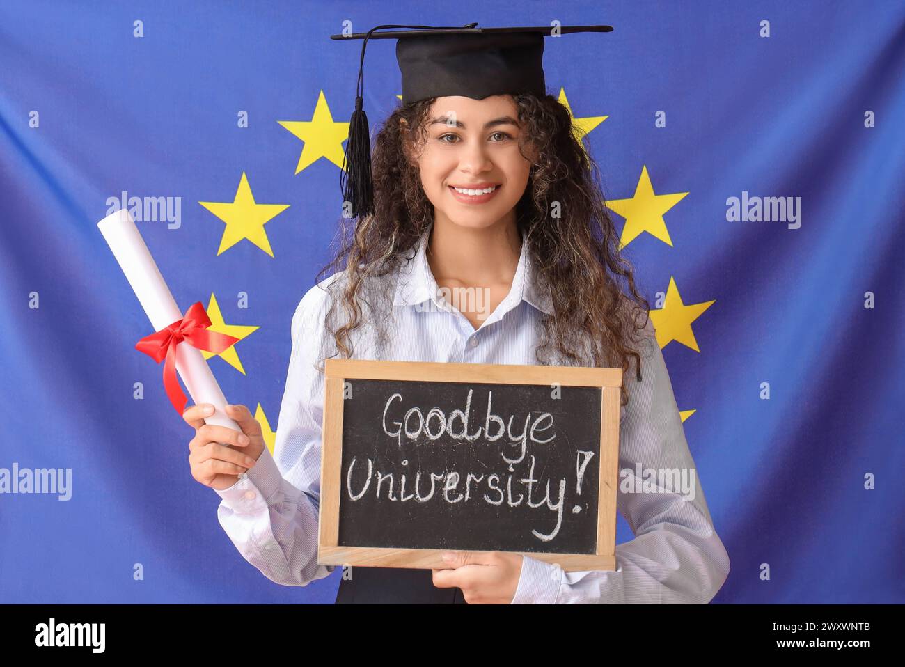 Studentessa afroamericana laureata in possesso di diploma e lavagna con testo ADDIO UNIVERSITÀ su sfondo bandiera UE Foto Stock