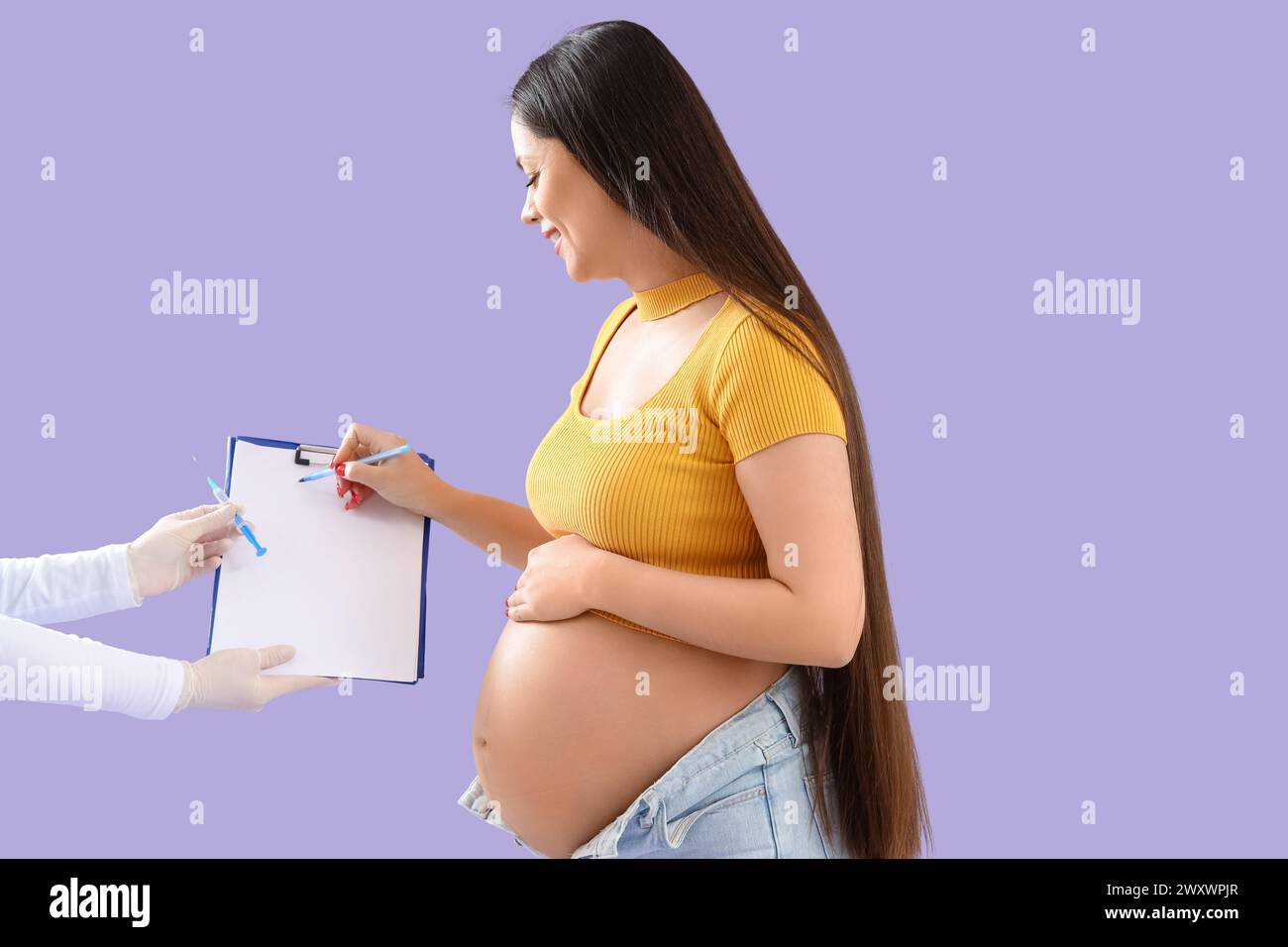 Giovane donna incinta che si iscrive alla vaccinazione su sfondo lilla Foto Stock