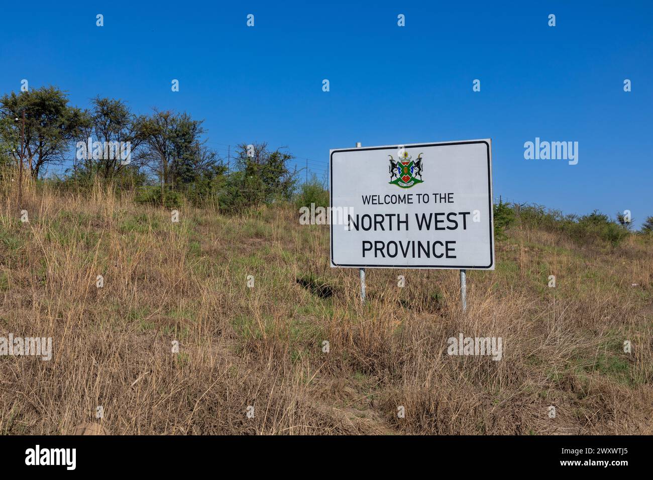 Benvenuto al cartello della provincia nord-occidentale a destra della cornice e copia lo spazio a sinistra, con alberi ed erba come sfondo. Foto Stock