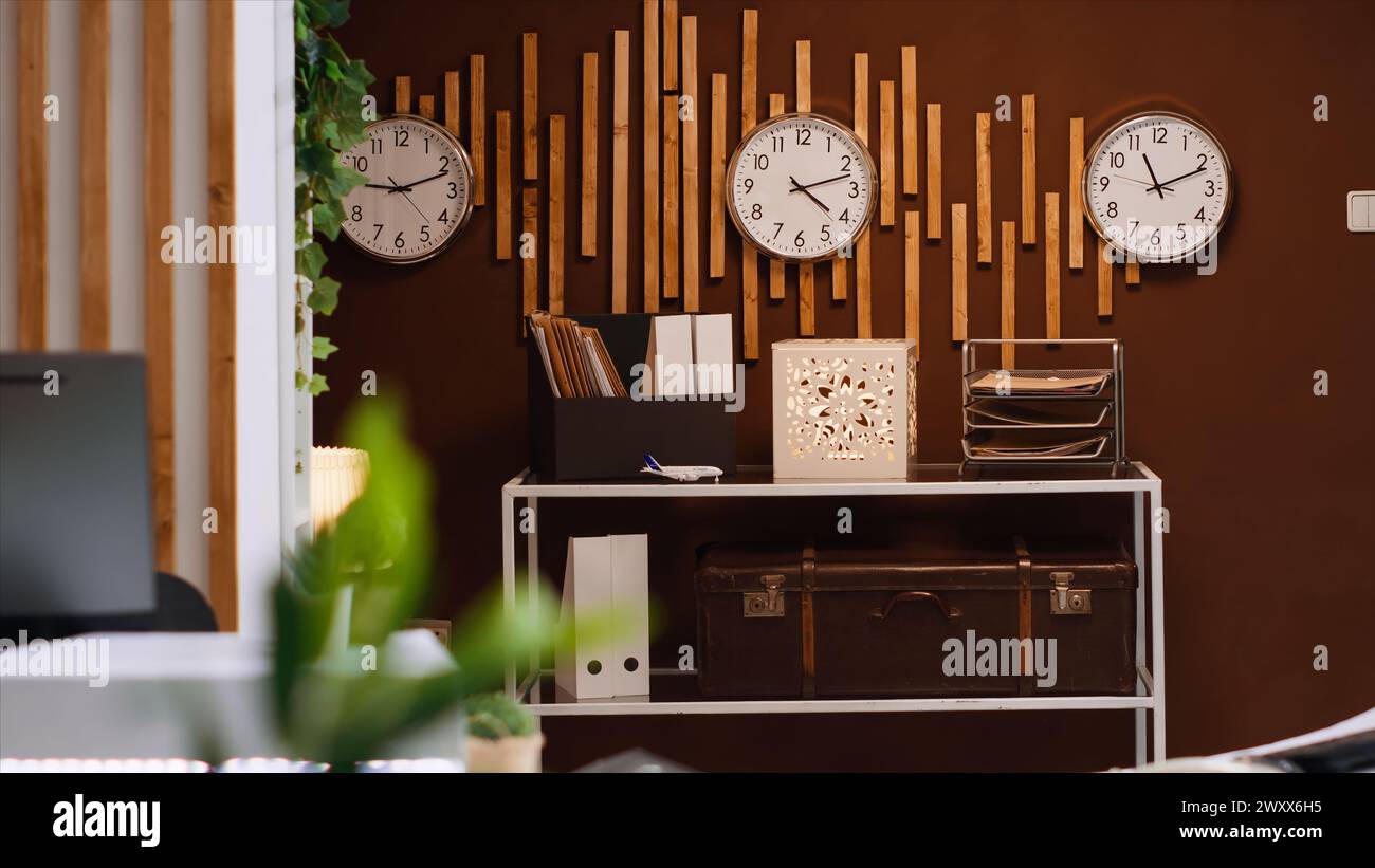 Banco ricevimento e lobby vuoti nel lussuoso resort di vacanza con orologi che mostrano diversi fusi orari internazionali. Moderna reception e zona lounge per ospiti e viaggiatori, industria dell'ospitalità. Foto Stock