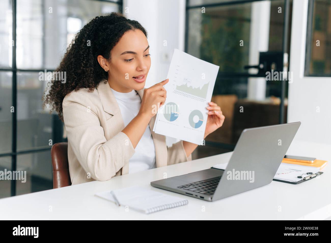 Consulenza finanziaria online. Imprenditrice brasiliana o ispanica di successo, top manager finanziario, che mostra i suoi colleghi tramite videoconferenza online, discute di strategia, sorridendo Foto Stock