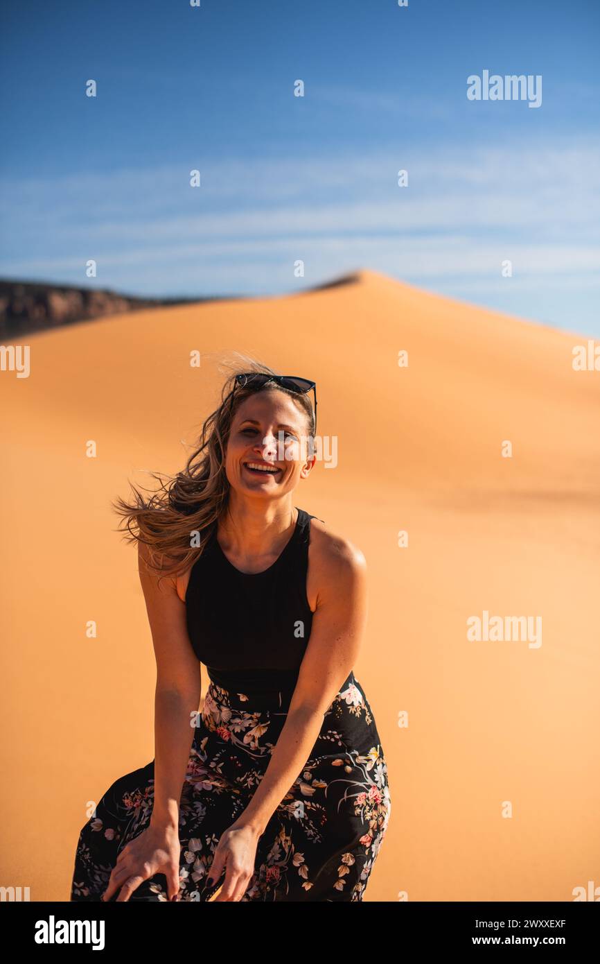Donna che cammina su una duna di sabbia nel deserto nel Coral Pink Sand Dunes State Park, Utah Foto Stock