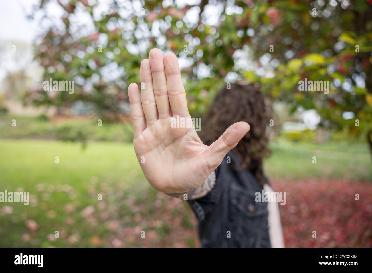 Donna che tiene la mano alla fotocamera Foto Stock