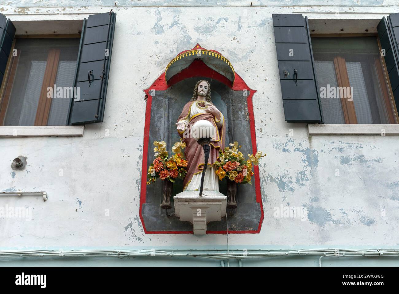 Figura di Cristo con baldacchino su una casa, Burano, Venezia, Veneto, Italia Foto Stock