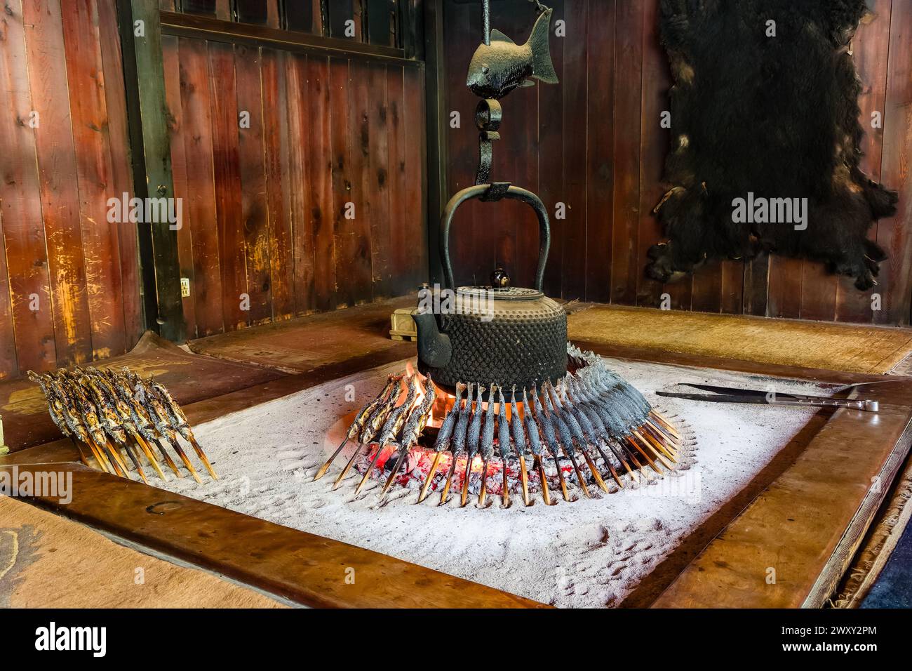 Tradizionale camino giapponese in un rifugio di montagna che cucina Iwana appena pescata (carro alla griglia) Foto Stock