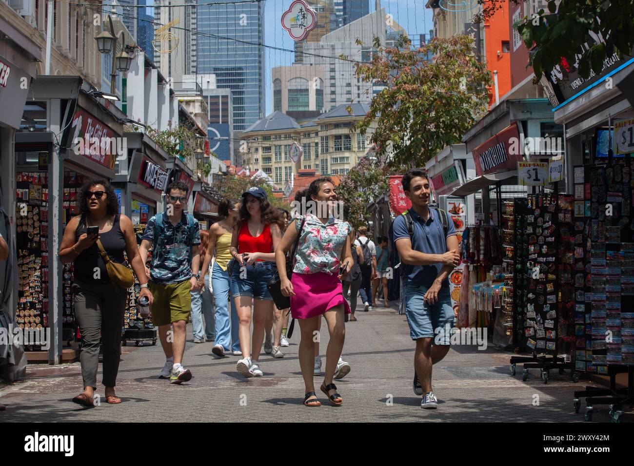 3 aprile 2024. I giovani turisti viaggiatori che viaggiano felicemente, sperimentano l'atmosfera di Chinatown Street in una bella giornata di clima tropicale. Città di Singapore. Foto Stock