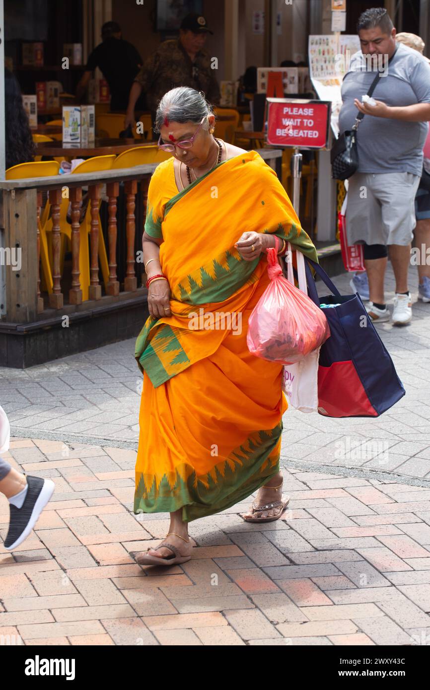 3 aprile 2024. Vista verticale di una donna anziana indiana nell'abbigliamento tradizionale di Sari, cammina lungo Chinatown Street. Singapore. Foto Stock