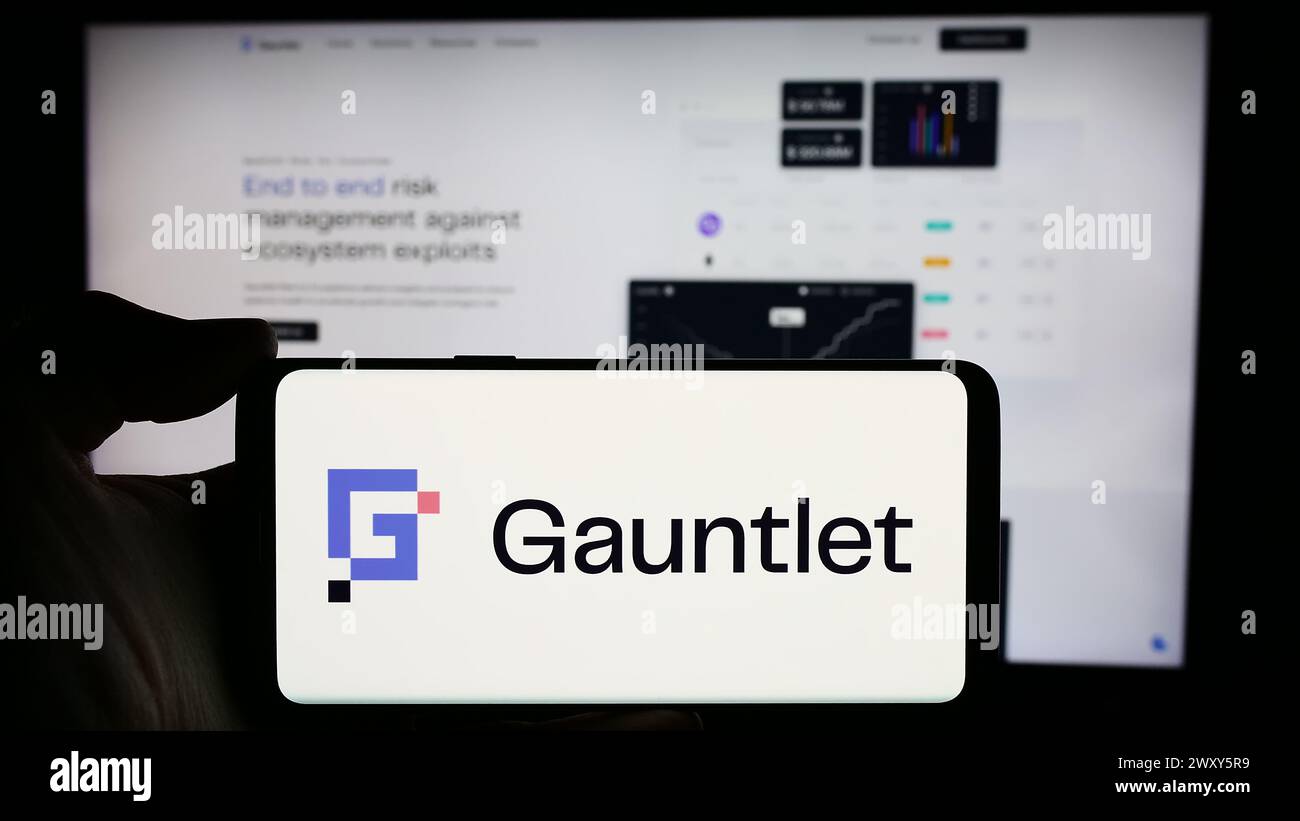 Persona che detiene un cellulare con il logo della società statunitense di soluzioni Defi Gauntlet Networks Inc. Di fronte alla pagina Web aziendale. Mettere a fuoco il display del telefono. Foto Stock