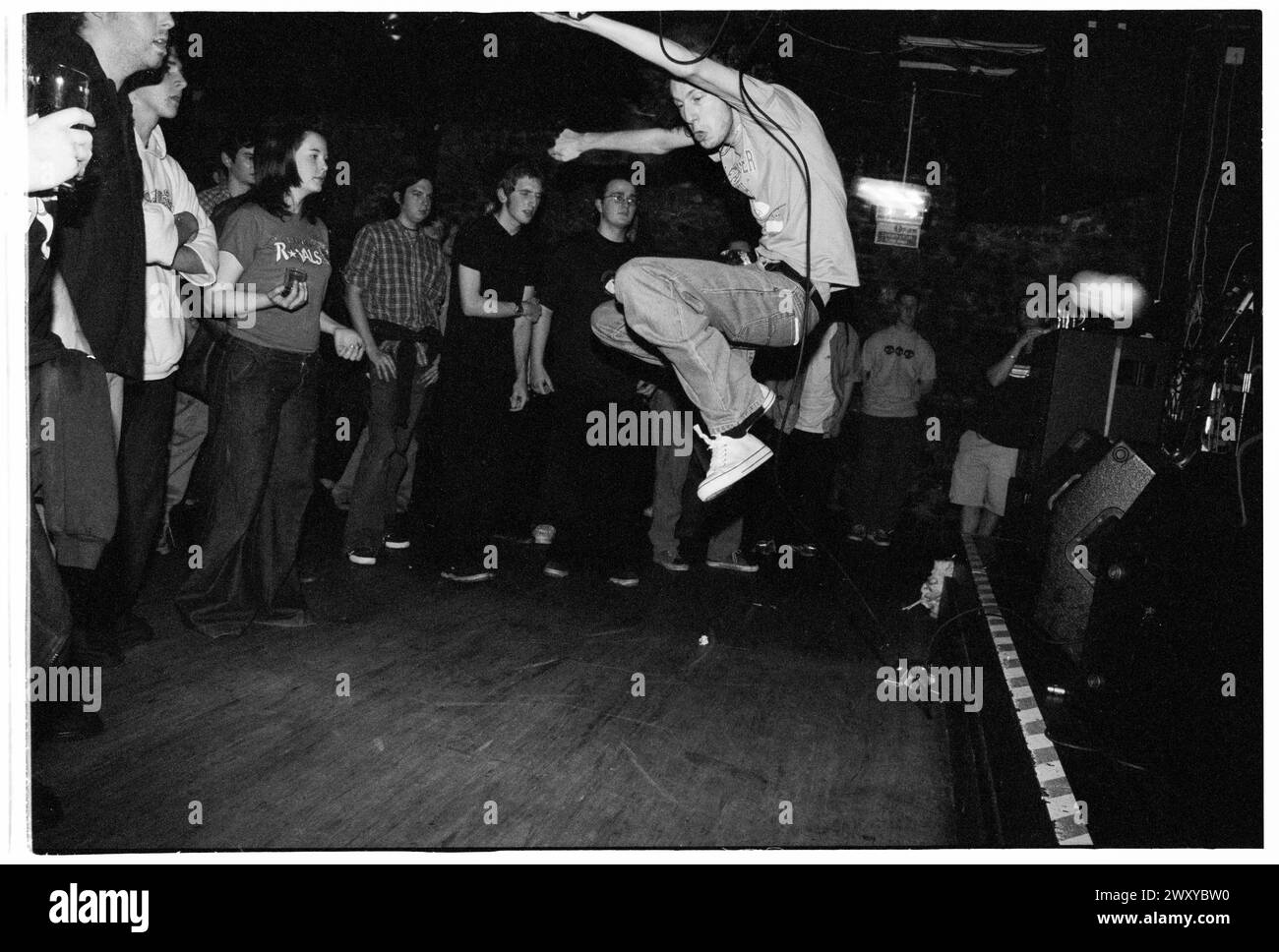 HUNDRED REASONS, EMO CONCERT, 2001: Colin Doran della band Emo rock Hundred Reaons salta in mezzo alla folla suonando al Clwb Ifor Bach Welsh Club in Galles, Regno Unito, 14 maggio 2001. Foto: Rob Watkins. INFO: 100 Reasons, un gruppo rock post-hardcore britannico formatosi nel 1999 a Londra, ha guadagnato il plauso per le loro energiche esibizioni dal vivo e la scrittura emotiva delle canzoni. Successi come "If i Could" e "Silver" hanno mostrato il loro suono dinamico, guadagnando loro un seguito devoto nella scena musicale dei primi anni '2000. Foto Stock