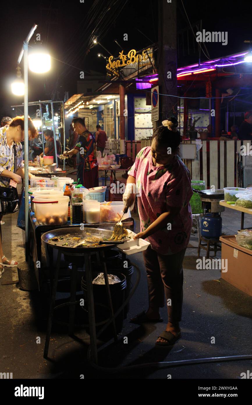 Eine thailändische Köchin verkauft ihr frisch gekochtes Essen uno stand einem Streetfood Foto Stock