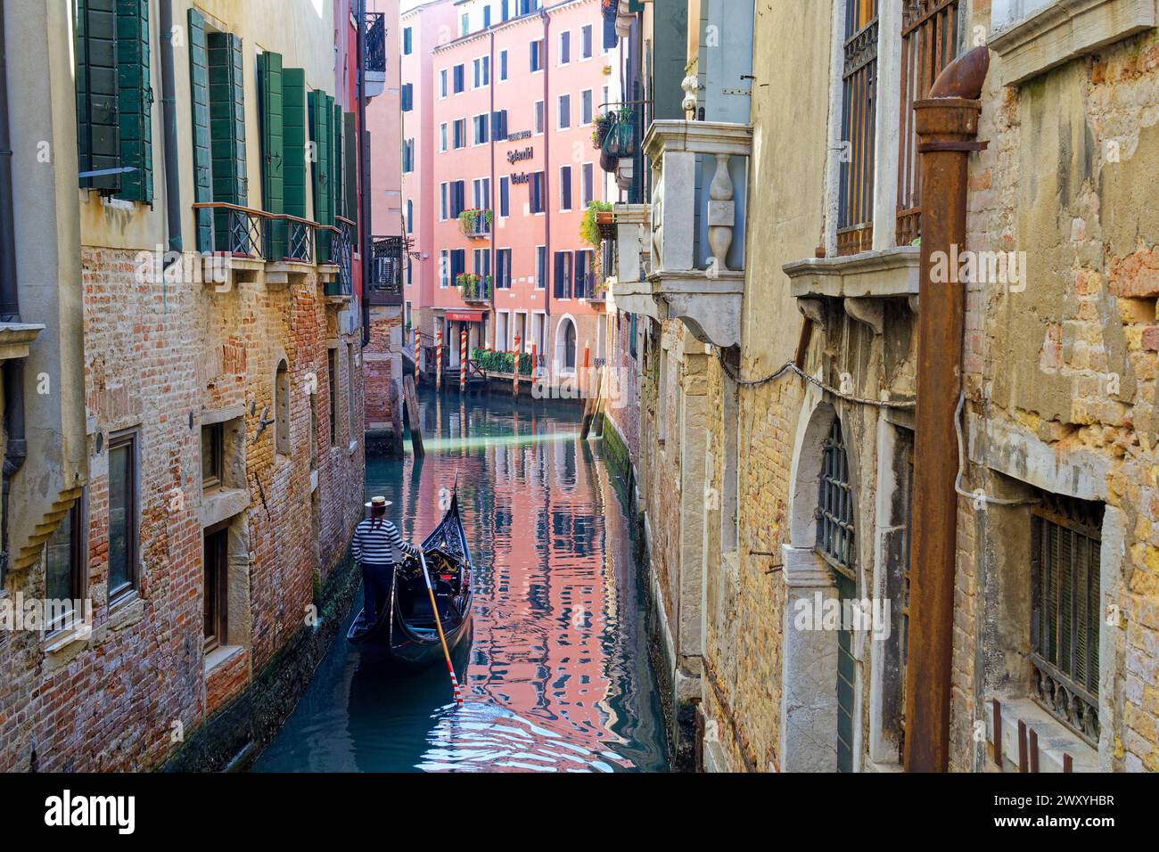Italia, Venezia: Gondoliere che naviga su uno stretto canale Foto Stock